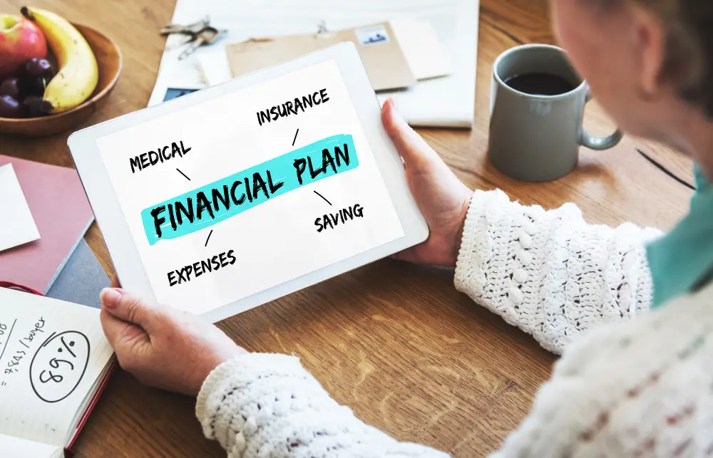Woman reviewing financial planning strategies on a tablet with keywords like savings, insurance, and medical expenses – modern financial education setup at home.